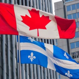 quebec-and-canada-flags-fluttering-in-the-wind-together-in-the-downtown-area-of-montreal